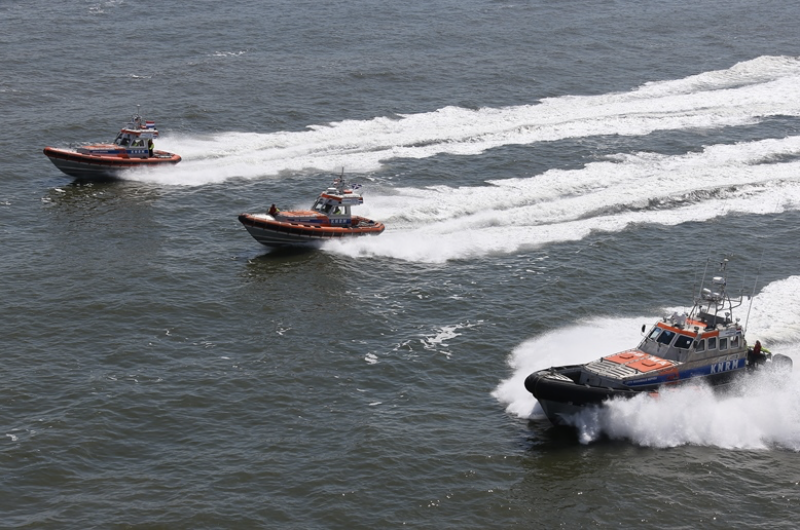 Boten van KNRM rukken uit op zee.